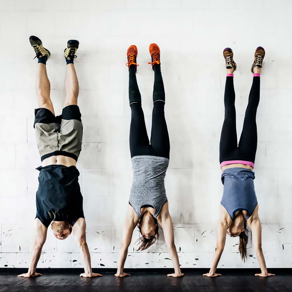 Ekonomer står på händer mot en vägg